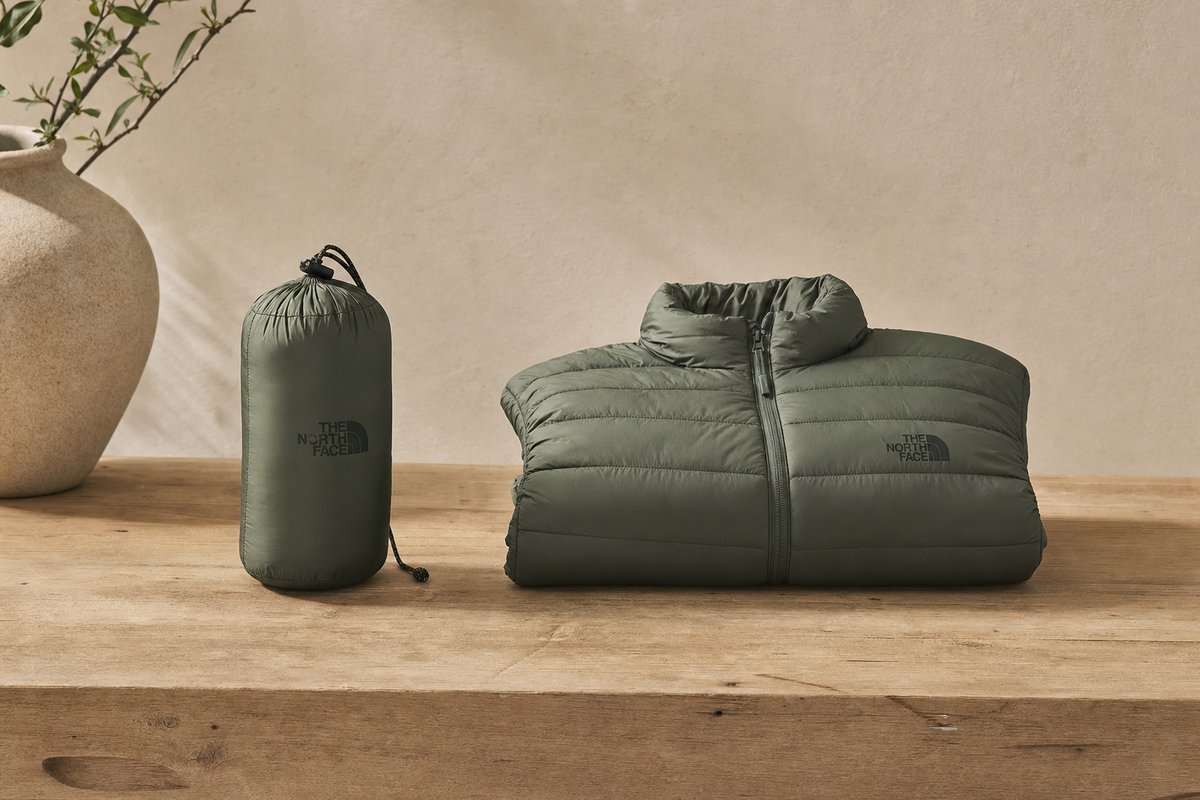 Packable insulated down or synthetic jacket compressed next to its stuffed size to show portability